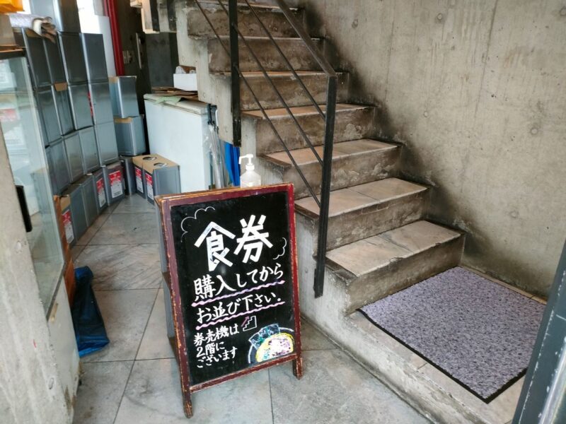 ２階への階段前にある食券購入を促す看板